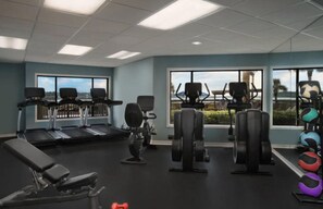 Ein Fitnessstudio mit Laufbändern, Kraftgeräten und Übungsbällen.