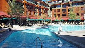 Relax by the pool, surrounded by lounge chairs and umbrellas, with a staircase leading into the water.