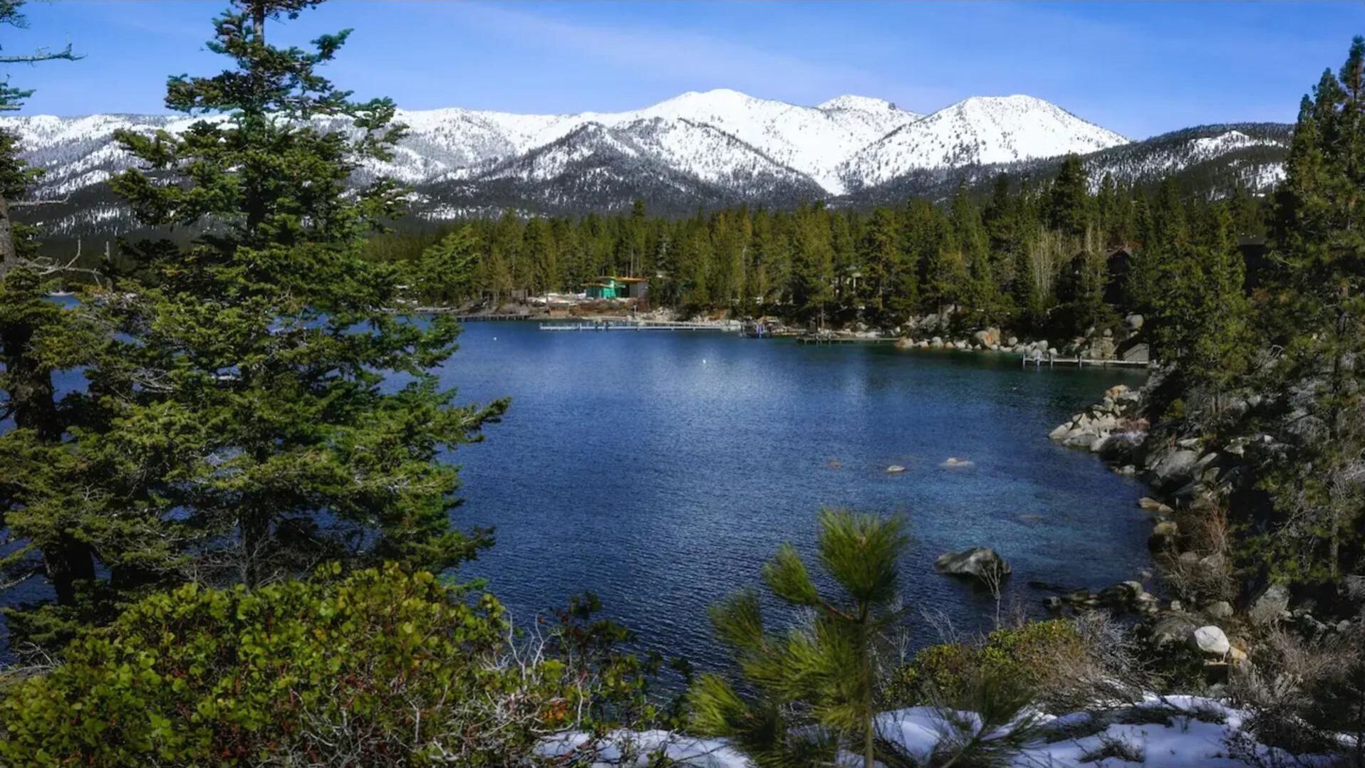 Un lago rodeado de montañas y un bosque frondoso.