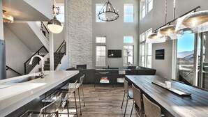 A modern kitchen with a large island, bar stools, and pendant lighting. - Gorgeous Jordanelle Lake Property - 4BD/3.5BA (Hideout)