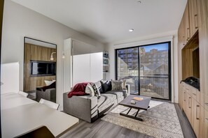 A modern living room with a sofa, a coffee table, and a TV.