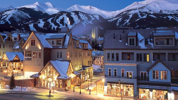 Un pueblo cubierto de nieve con edificios de madera tradicionales y un paisaje montañoso.