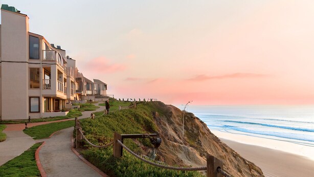 A coastal hotel with a pathway leading to the beach, overlooking the ocean. - Oceanfront Coral Reef (Solana Beach)