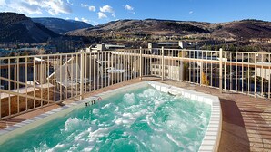 A hot tub on a deck with a mountain view.