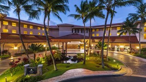 A hotel with a pool, palm trees, and a sign for the Harleton Vacation Club.