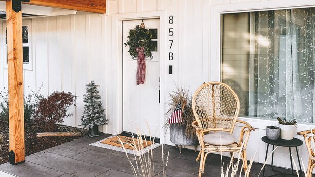 A modern house with a wooden ceiling, a white door with a wreath, and a number '857B' on the wall. - Cottage with gated driveway near downtown & river (Grants Pass)