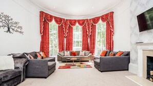 Ein Wohnzimmer mit zwei grauen Sofas, einem Couchtisch und einem Kamin.