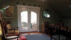 Ein Wohnzimmer mit Kamin, einem Essbereich und einem großen Fenster mit Blick ins Freie.