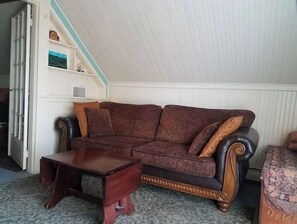 A living room with a brown sofa, a wooden coffee table, and a patterned rug.