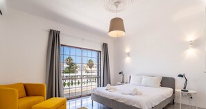 Ein modernes Schlafzimmer mit einem großen Bett, einer Couch und einem kleinen Tisch.