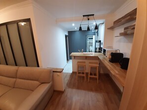 Una cucina moderna con piani in legno, un'isola centrale con sgabelli e un forno a incasso.