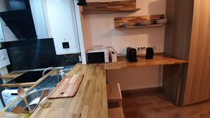 A modern kitchen with a wooden countertop, a built-in stove, and a sink. - 2-room apartment, near RER, bus and castle (Rambouillet)