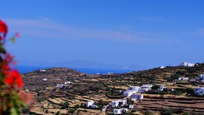 Uma vila costeira com campos em socalcos e edifícios brancos, provavelmente um destino turístico.