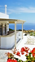 Un edificio blanco con un espacio al aire libre techado y vistas al mar.