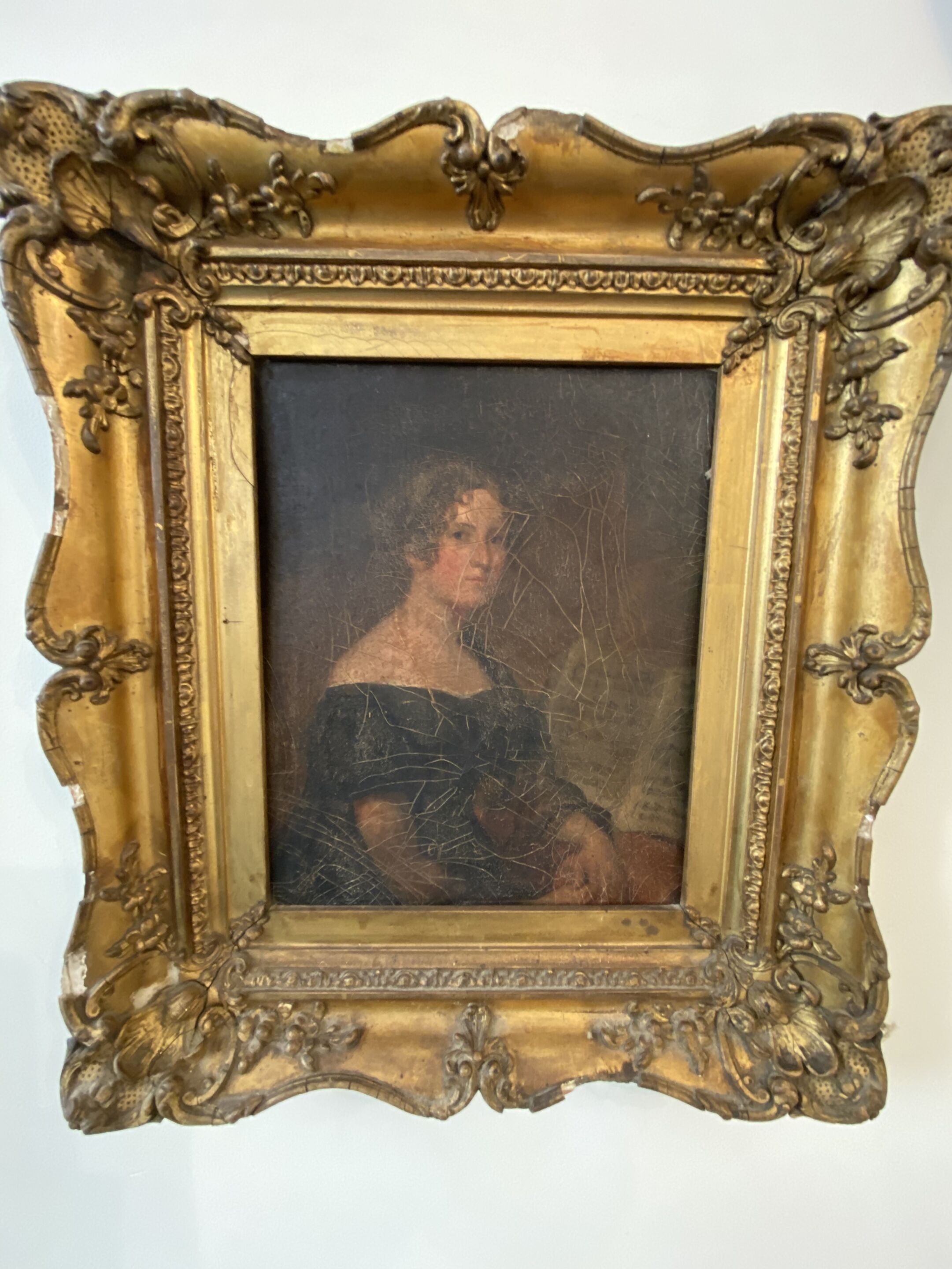 Una obra de arte enmarcada con un marco dorado ornamentado con diseños intrincados.