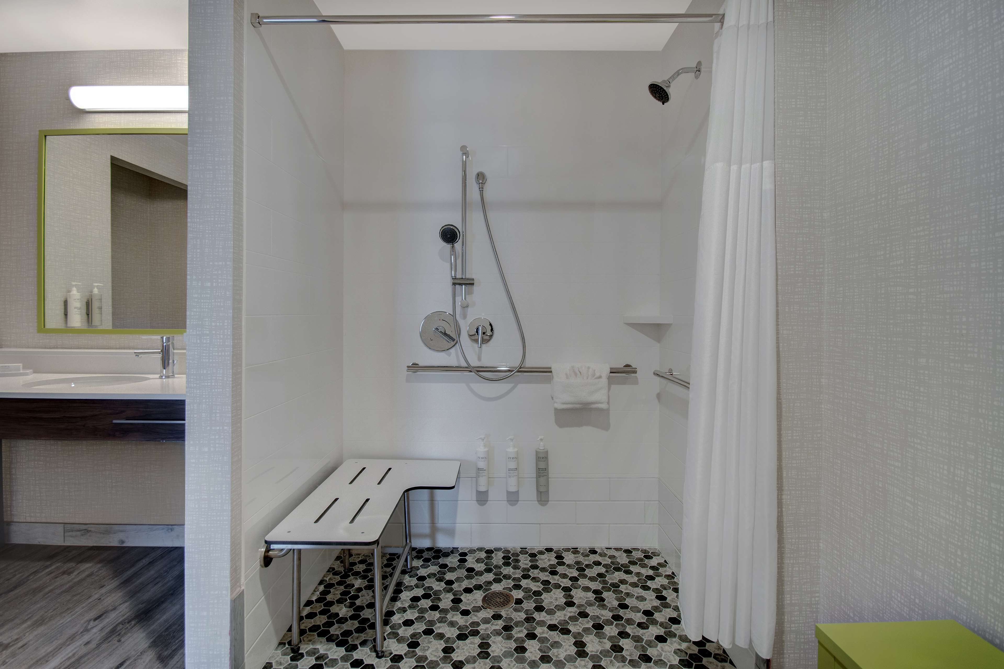 A modern bathroom with a shower, a sink, and a mirror.