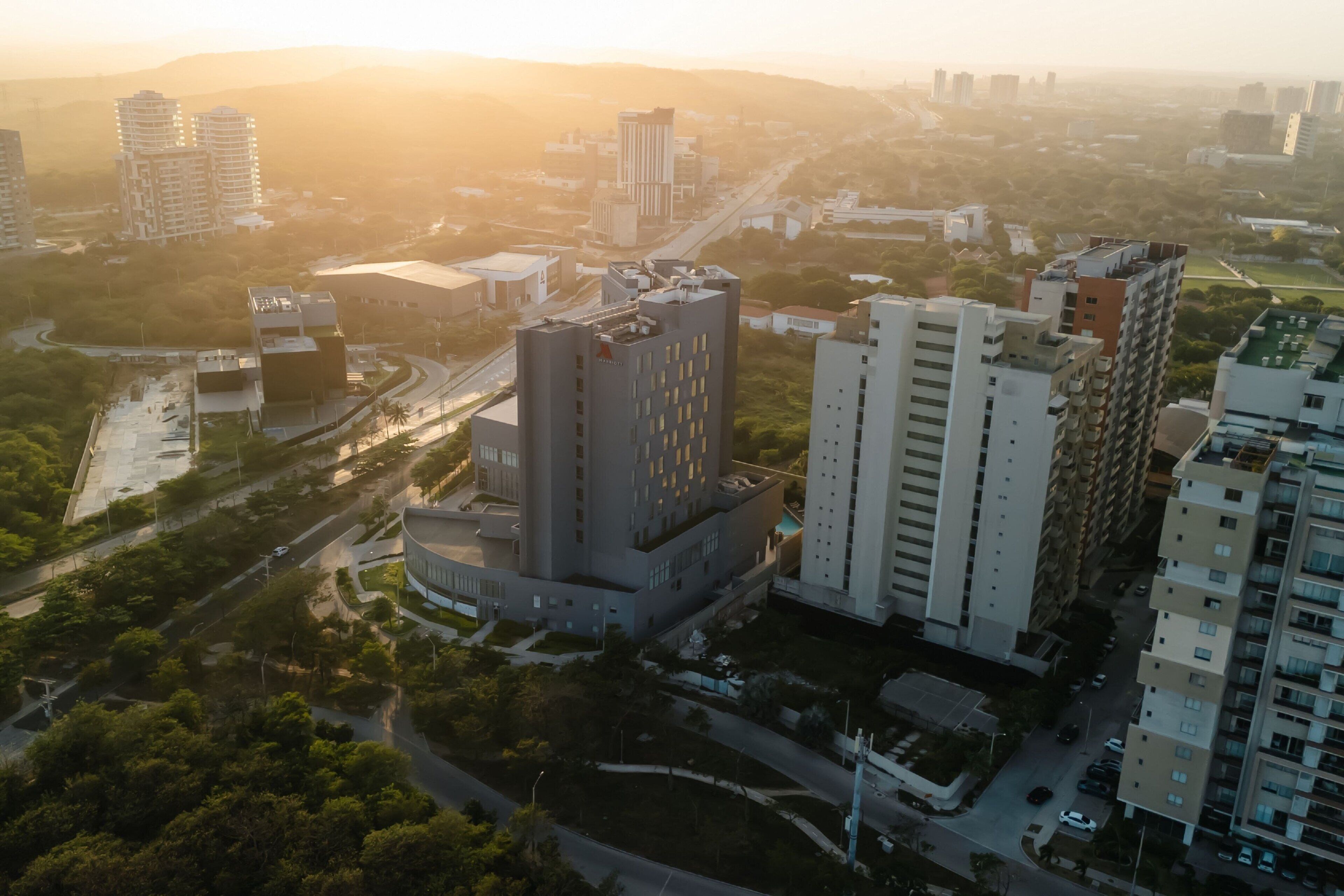 Vista aérea de un paisaje urbano con edificios modernos, calles y áreas verdes.