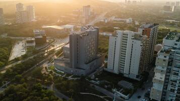 Vista aérea de un paisaje urbano con edificios modernos, calles y áreas verdes.