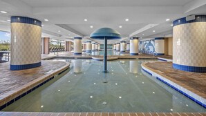 Una piscina interior con columnas a cuadros y un pilar central.
