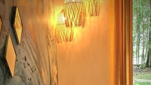 Een kamer met een houten stoel, een tafel en een hanglamp.