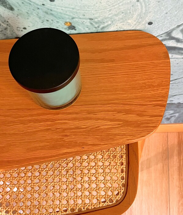 A wooden table with a woven tray and a cylindrical container.