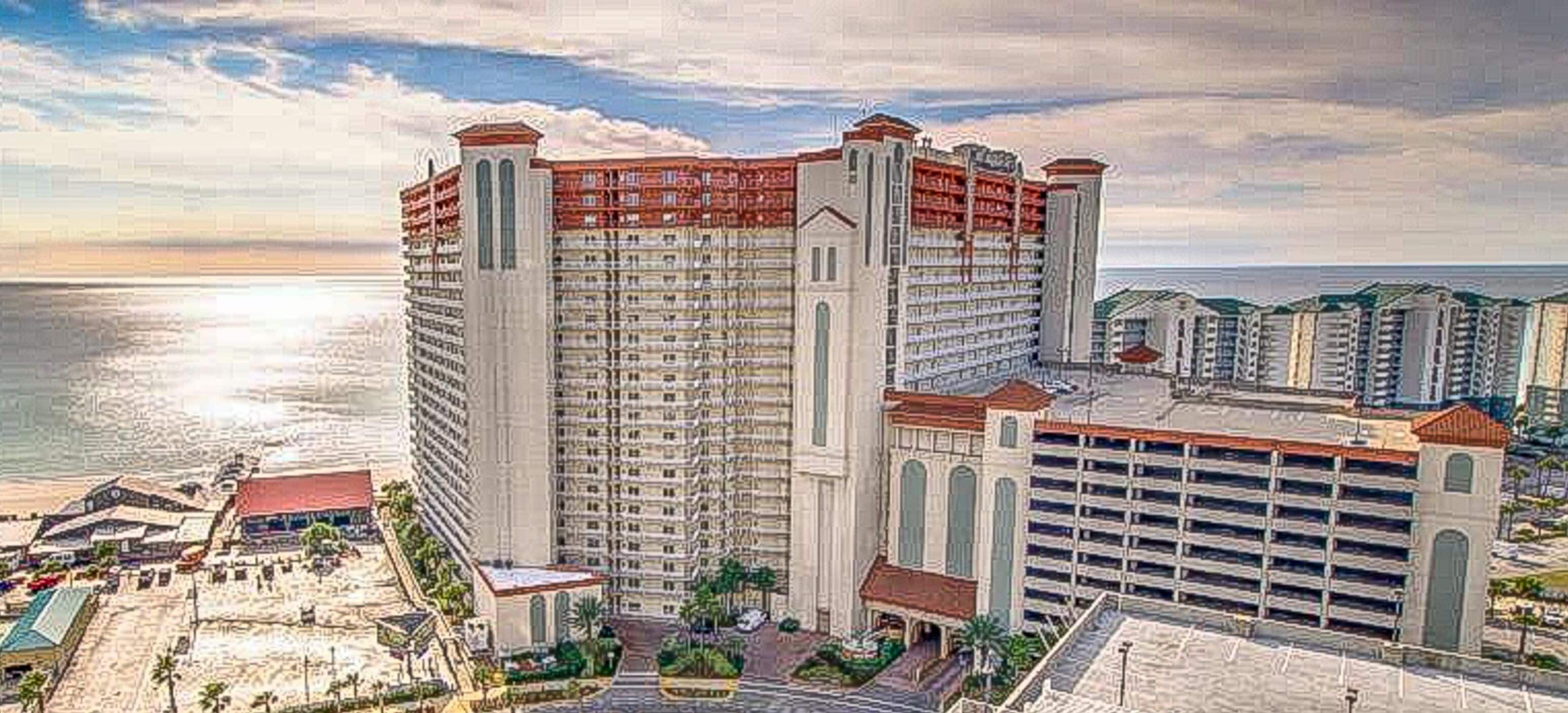 A high-rise hotel with multiple floors, a parking garage, and a beach view.