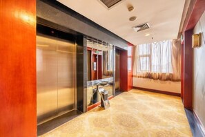 A hotel lobby with a marble floor, an elevator, and a window with curtains. - Federation AVIC Business Hotel (Xi'an Bell and Drum Tower) (Xi'an)