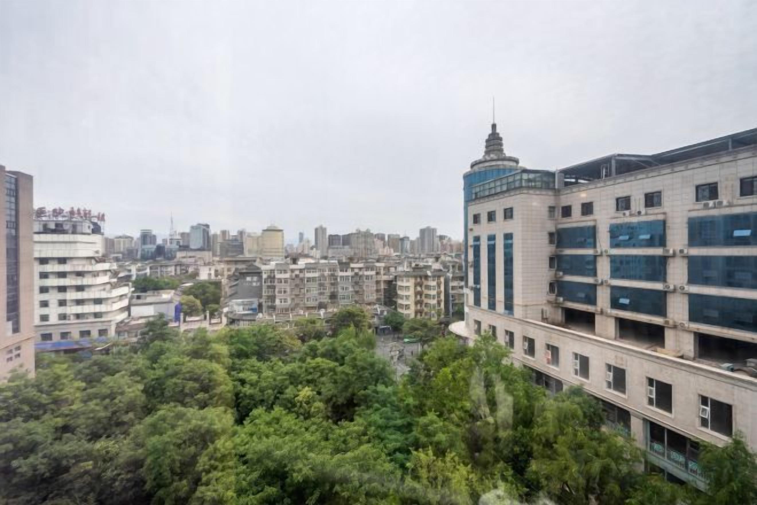 A cityscape with a mix of modern and older buildings, dense urban environment, and a view of the city skyline.