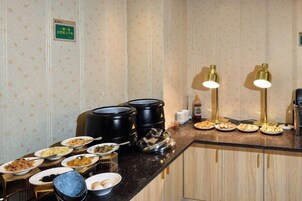 Montaje de bufé con diversos platos y una estación de café.