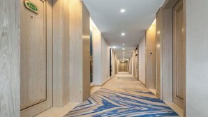 A long, well-lit hallway with wooden doors and a patterned carpet. - Vienna Hotel (Puning Huancheng South Road High-speed Railway Station) (Puning)