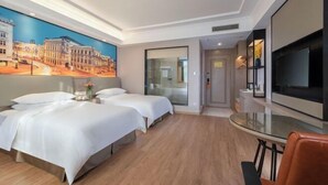 A hotel room with two beds, a TV, a glass table, and a painting on the wall. - Vienna Hotel (Puning Huancheng South Road High-speed Railway Station) (Puning)