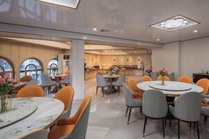 Un comedor moderno con mesas redondas, sillas y una isla central.
