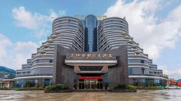 Un hotel de varios pisos con una fachada curva distintiva y una entrada central.
