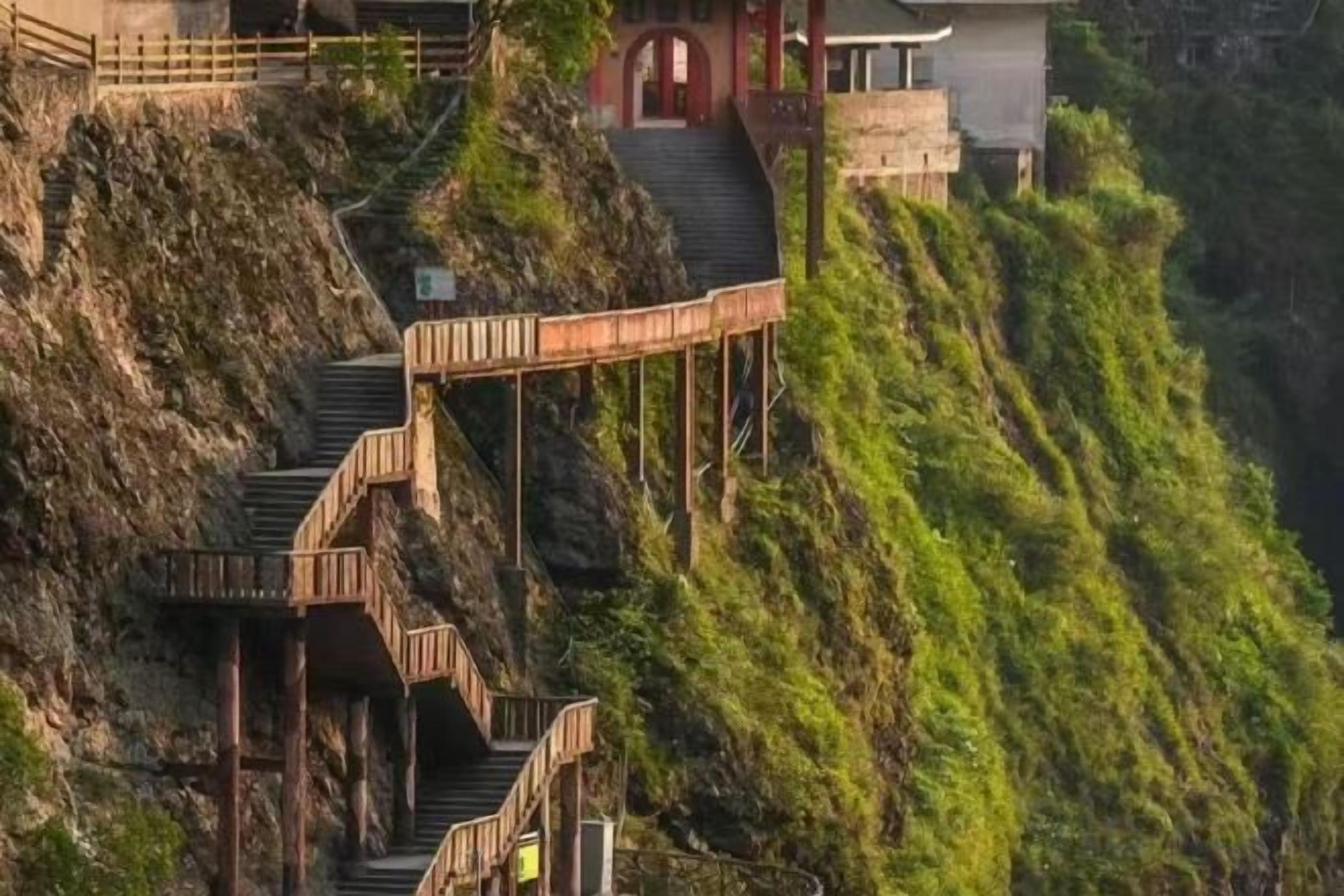 Eine Treppe führt zu einem Gebäude auf einer Hügelkuppe mit Blick auf die umliegende Landschaft.