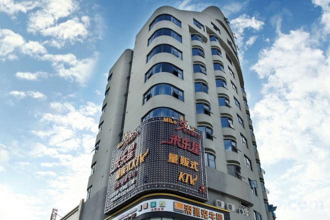 A tall building with multiple floors and a large digital billboard displaying advertisements.