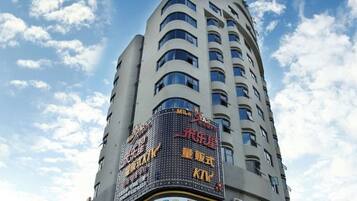 Un edificio alto con varios pisos y un gran cartel digital que muestra anuncios.