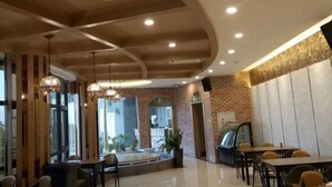 A modern restaurant with brick walls, wooden ceiling beams, and pendant lighting. - Suofeike Hotel (Pinghe)