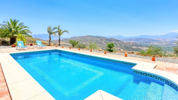 Una piscina rectangular con agua cristalina y un borde de baldosas.