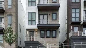 A multi-story residential building with balconies, a stone facade, and a staircase leading to the entrance. - Beautiful Nashville Home – Near Broadway (Nashville)