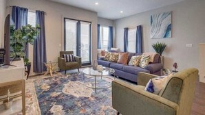 A living room with a sofa, armchairs, a coffee table, and a rug. - Beautiful Nashville Home – Near Broadway (Nashville)