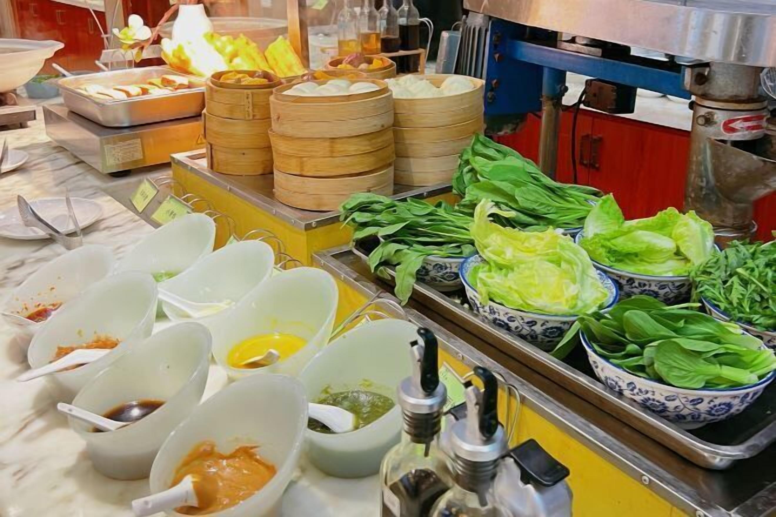 A buffet setup with various food items and condiments.