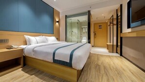A modern hotel room with a large bed, bedside tables, a wardrobe, and a television. - City Comfort Inn Guilin Department Store (Guilin)