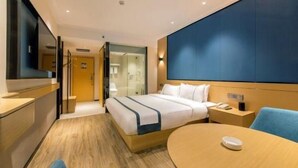 A hotel room with a bed, bedside table, chair, and a TV. - City Comfort Inn Guilin Department Store (Guilin)
