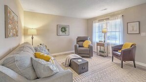 A living room with a grey sofa, two armchairs, a small table, and a lamp. - Stay near all Chas attractions, quiet comfort with fenced yard! (Goose Creek)
