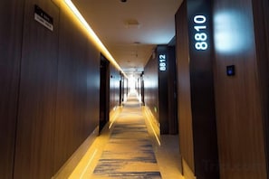 A hotel corridor with a carpeted floor and wooden walls. - Tang Dynasty Hotel (Ningjin)