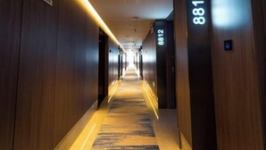 A hotel hallway with wooden walls and a carpeted floor. - Tang Dynasty Hotel (Ningjin)
