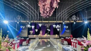 A stage with a floral arrangement, chandeliers, and a reflective floor. - Tang Dynasty Hotel (Ningjin)