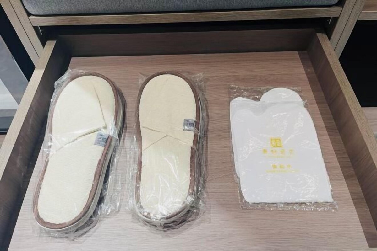 Un cajón con tres pares de zapatillas envueltas en plástico.