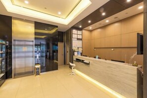 A modern hotel lobby with a reception desk, seating area, and a large window. - Jinjiang Inn Select (Xuzhou High-speed Railway Huaihai Huanqiugang) (Xuzhou)