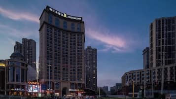 A high-rise hotel with a prominent sign, surrounded by other buildings and a clear sky.